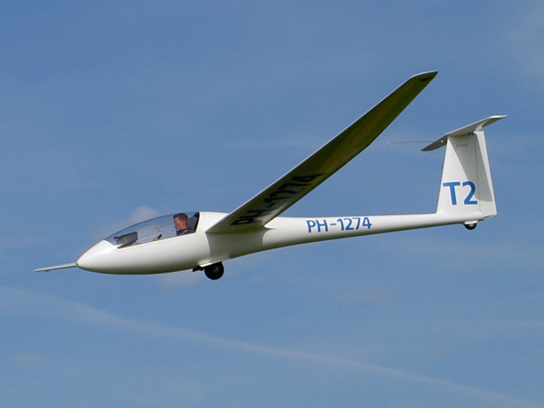A sailplane soaring in flight against a clear sky